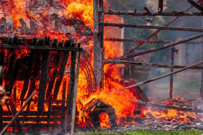 A fire in a residential neighborhood consumes a dog house.